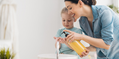 Woman-Helps-Child-Wash-Hands-Soap