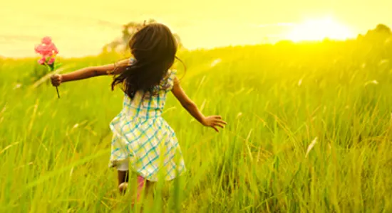 girl-running-in-grass-as-sun-sets