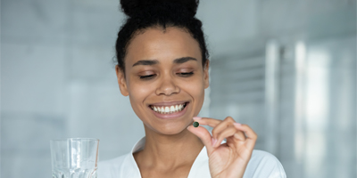 woman-holds-spirulina-dietary-supplement-pill