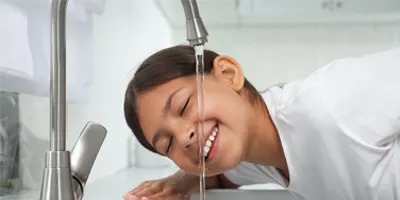 girl-drinks-water-from-kitchen-faucet
