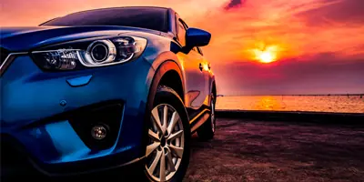 blue-car-on-beach-during-sunset