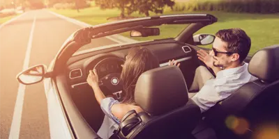 couple-drives-convertible-on-sunny-day